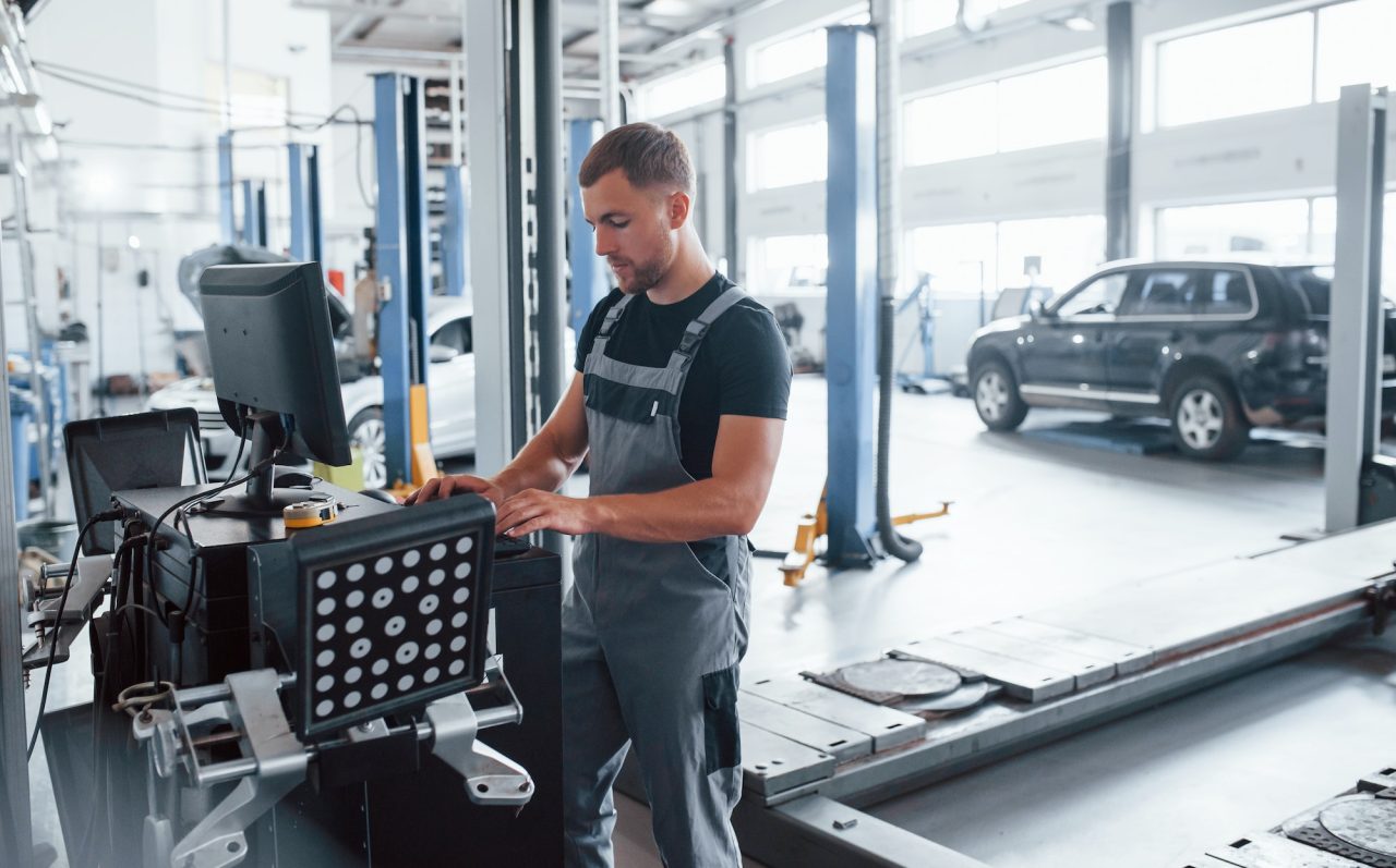 looks-at-keyboard-man-at-the-workshop-in-uniform-use-computer-for-his-job-for-fixing-broken-car.jpg